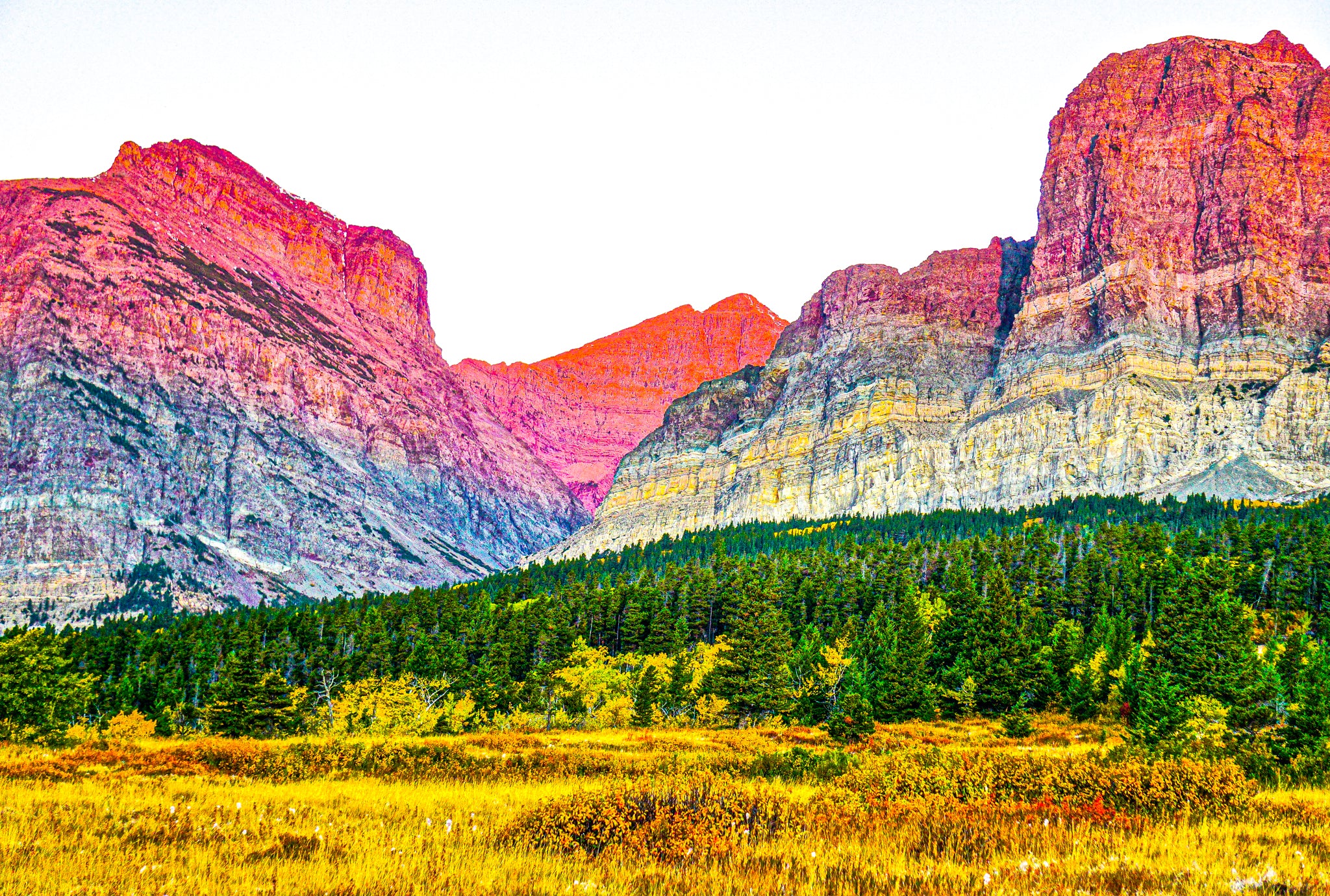 If you have stumbled across this photograph, then a gem has been discovered. As one of the most clear and colorful images in this collection with realistic tint, this image offers a magnificent view of the lush alpine terrain in Montana next to a vibrantly hued tower of rockface